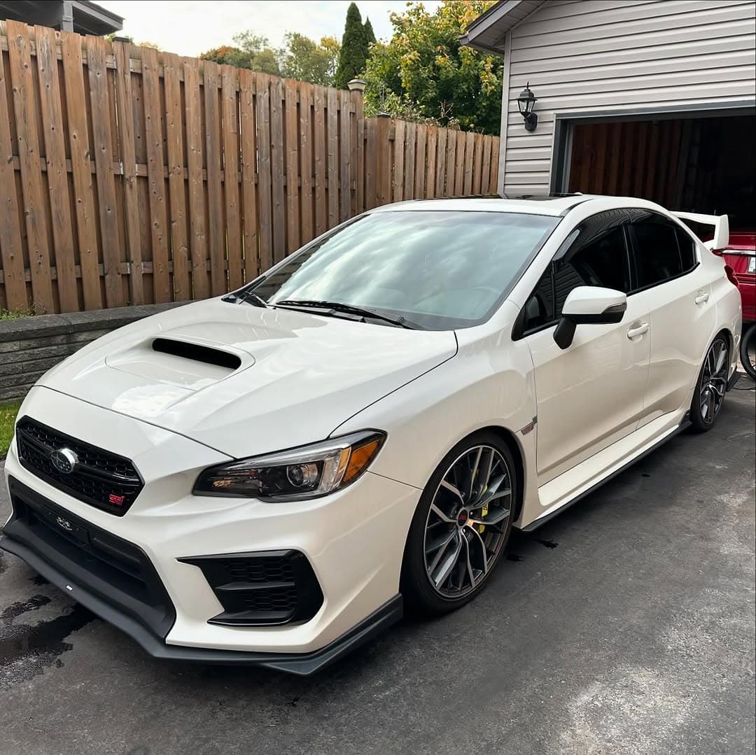 A white Subaru WRX STI freshly detailed in a Niagara driveway